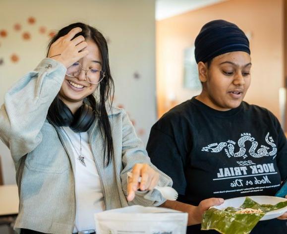 Two female students cooking together.